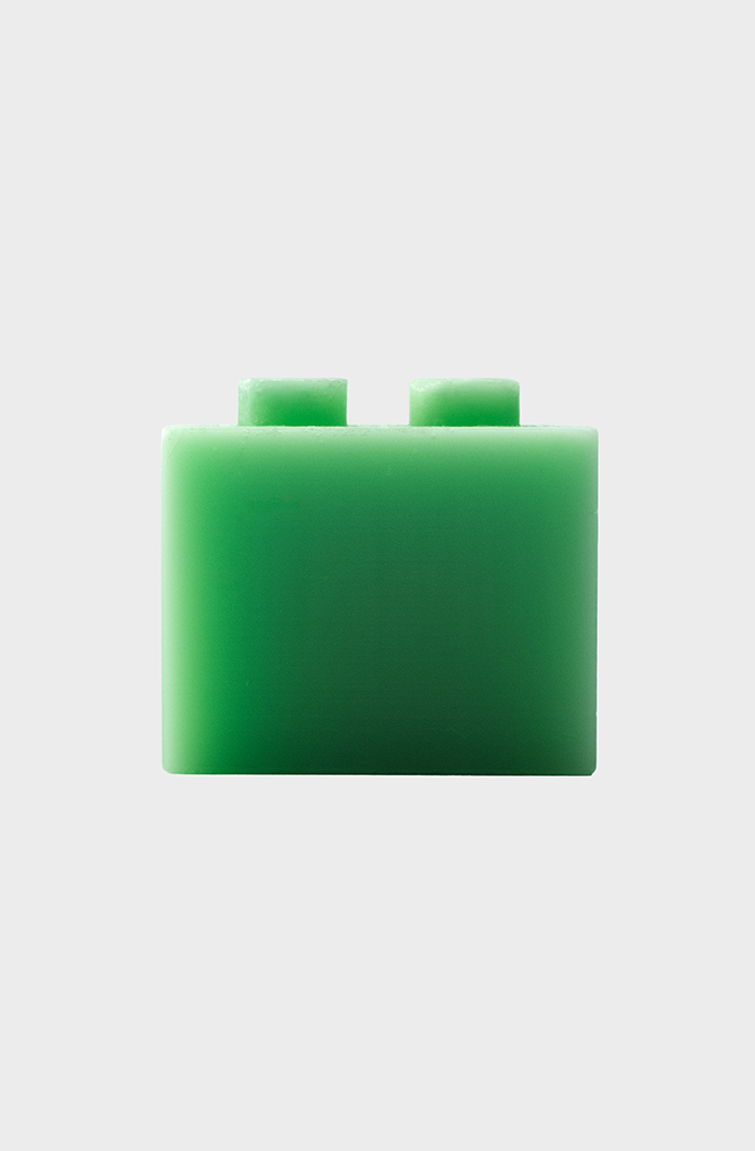 Green rectangular candle isolated on a light gray background showcasing its two small protruding connectors at the top. Ideal for creative building and educational play.